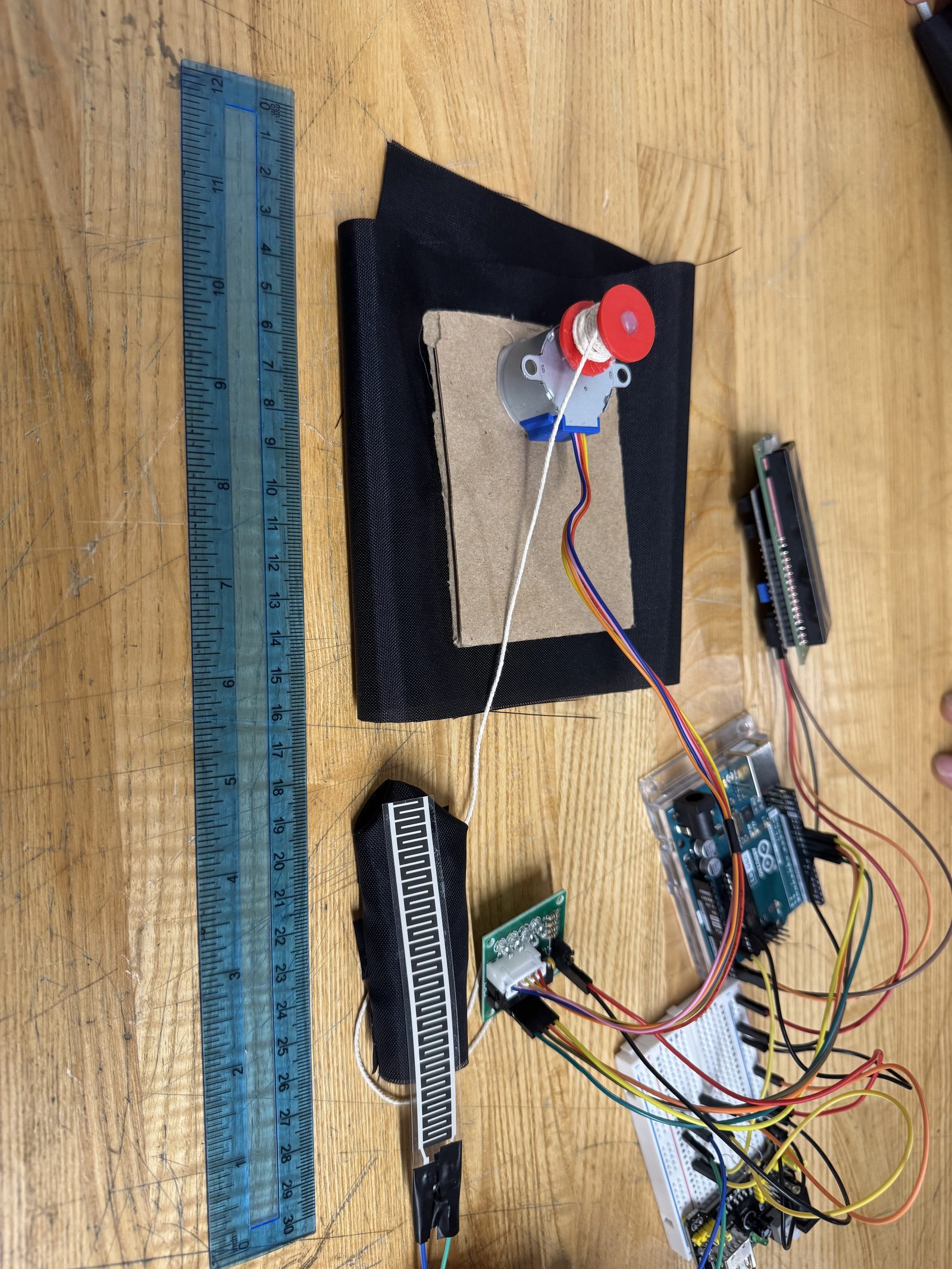 Wearable flex sensor rig with an LCD readout, breadboard, and microcontroller on the bench